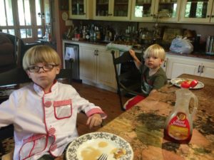 Two adorable little blonde hair babes eating pancakes