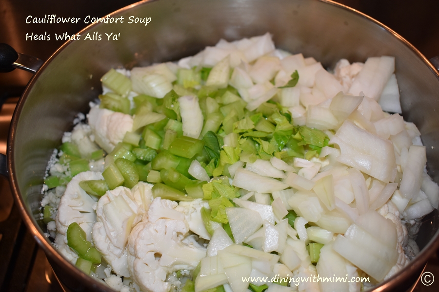 Cutting boardStock pot filled with water cauliflower, celery and onions Cauliflower Comfort Soup- Heals What Ails Ya' www.diningwithmimi.com