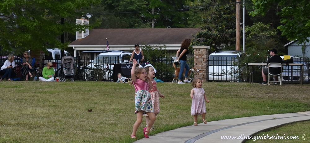 Trio of little girls and others enjoying the show at Hip Fairhope Outdoor Event www.diningwithmimi.com