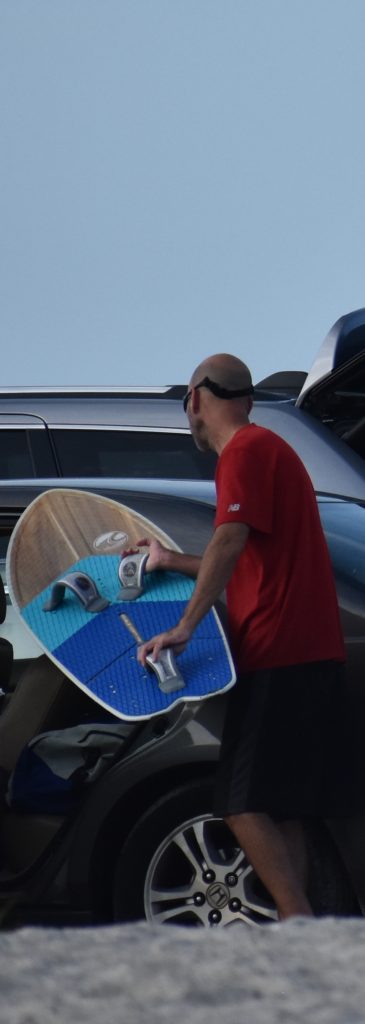 Young man storing his board in car for Unwind on Dauphin Island www.diningwithmimi.com