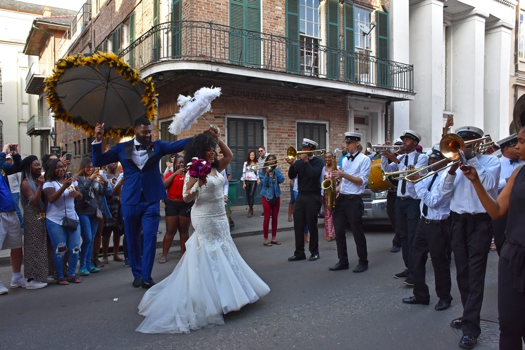 Beautiful Black Couple in full wedding attire dancing with parasols and Brass Band Need a quickie- Drop into New Orleans for 48 hours www.diningwithmimi.com