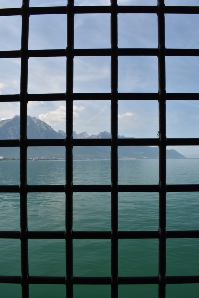 Castle window from Switzerland looking at Mountains and water www.diningwithmimi.com