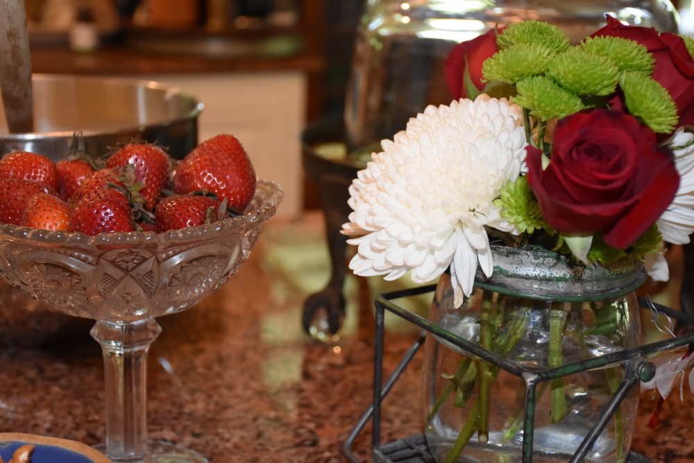 Small bouquet with roses, lime green and white flowers beside the strawberries for cake